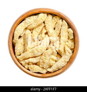 Soy curls, a soy based meat alternative, in a wooden bowl. Soya chunks, made from boiling and dehydrating soybeans, with a texture similar to chicken. Stock Photo