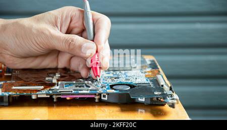 side view mechanic repairing motherboard Stock Photo