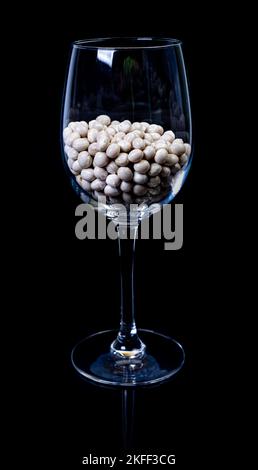 raw white beans in glass jar, wine glass. in bucket. raw white beans on black background. front view raw white beans, dropped from hand, isolated on b Stock Photo