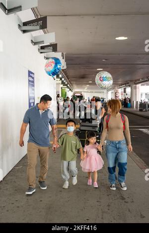 Coast Guard family walks together after being reunited at Los Angeles International Airport, September 13, 2022. The family had not been together since December of 2019 when China first went into lock and prevented the son from returning home. Stock Photo