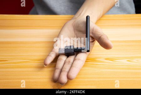 USB wifi black on hand, hand holding usb wifi Stock Photo