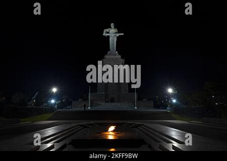 Statue of Mother Armenia in Victory Park in the evening, shot from below. Eternal flame with Mother Armenia statue in the background, in Haghtanak par Stock Photo