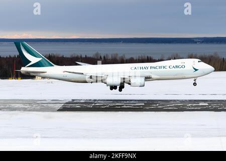 Cathay Pacific Cargo Boeing 747 freighter plane landing. Large cargo airplane 747-8F. Aircraft 748F arrival in at snow covered Anchorage Airport. Stock Photo