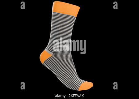 One volumetric sock with different lines isolated on black background. Colorful volumetric sock. Colored socks on the leg isolated on black background Stock Photo