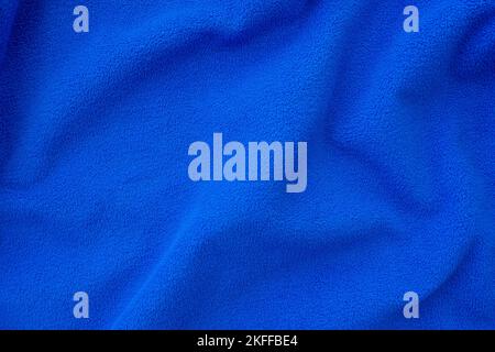 Bright blue fleece cloth. Crumpled, folded blue cloth as background or backdrop, top view Stock Photo
