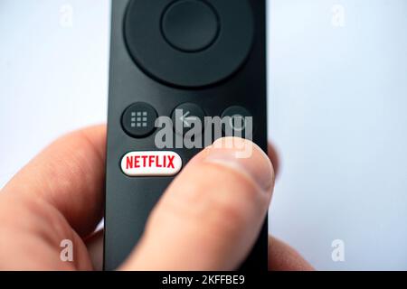 BERLIN - NOV 10: Close-up of button with Netflix logotype on a TV remote in Berlin on November 10. 2022 in Germany. Netflix, Inc. is an American subsc Stock Photo