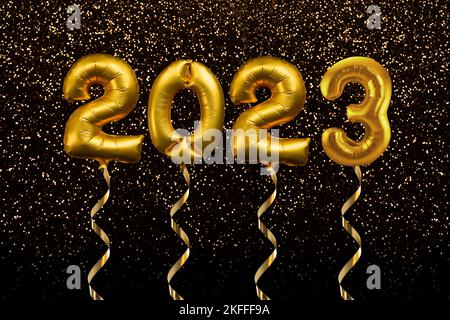 2023 written with golden balloons floating on gold glitter background, new year party greeting card Stock Photo