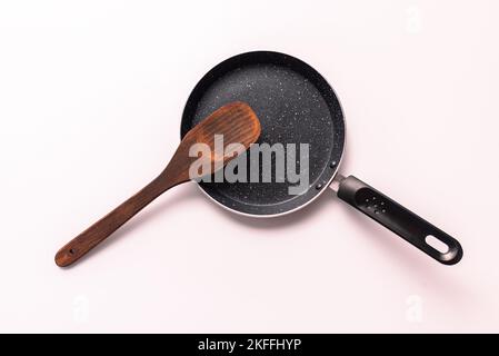 iron pan with wooden spatula top view isolated on white background Stock Photo