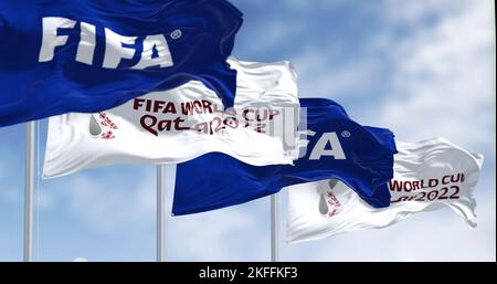 Doha, QA, nov 2022: Flags with FIFA and Qatar 2022 World Cup logo waving in the wind. The event is scheduled in Qatar from 21 November to 18 December Stock Photo