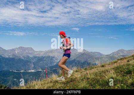 Rosa Khutor, Russia - September 10, 2022: female athlete running down steep mountainside in Rosa Wild Trail Stock Photo