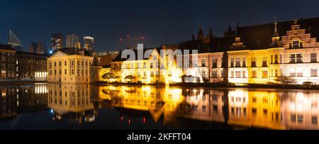 Panorama of The Hague at night, view of historical complex Binnenhof with famous Mauritshuis museum, Hofvijver lake and small octagonal building known Stock Photo