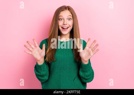 Photo of excited charming young lady wear green sweater smiling rising arms isolated pink color background Stock Photo