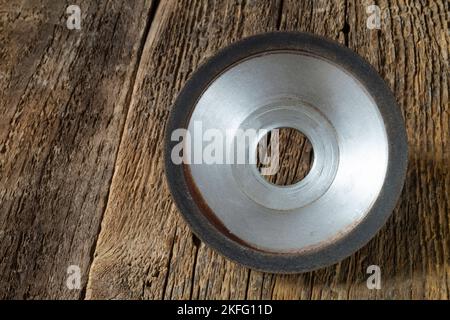 A locksmith tool for grinding on an old wooden table. Industrial objects on a dark background Stock Photo