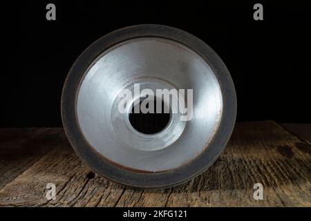 A locksmith tool for grinding on an old wooden table. Industrial objects on a dark background Stock Photo