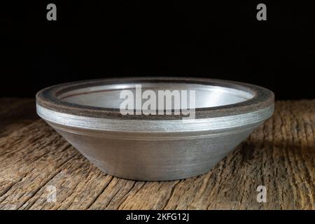 A locksmith tool for grinding on an old wooden table. Industrial objects on a dark background Stock Photo