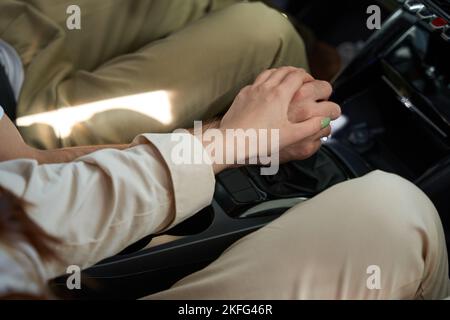Romantic couple holding hands on gear lever Stock Photo