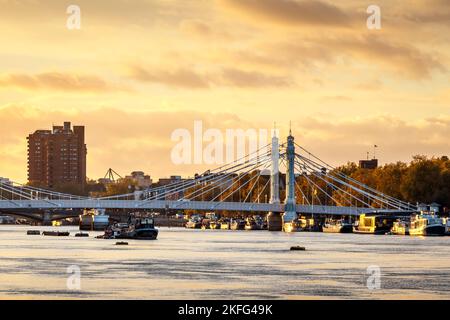A view of Albert Bridge on the River Thames at sunset, looking upriver from Chelsea Bridge, London, UK Stock Photo