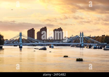 A view of Albert Bridge on the River Thames at sunset, looking upriver from Chelsea Bridge, London, UK Stock Photo