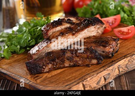 Delicious Baked Grilled Sliced pork belly with barbeque  sauce plating on wooden plate,  herbs and vegetables Stock Photo