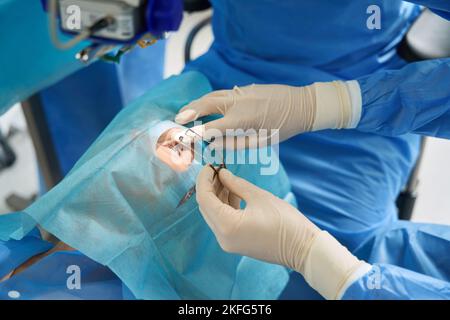 Doctor holding eyelid expander during the surgery Stock Photo