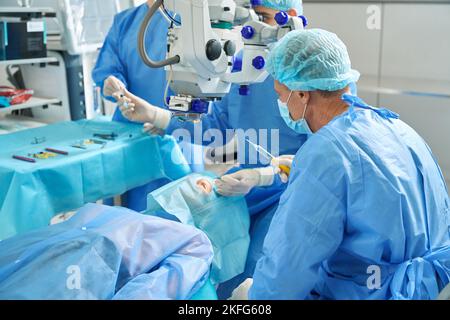 Two doctors doing laser vision correction in hospital Stock Photo