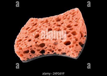 Macro shot of a surface of plastic red sponge isolated on black background. Close-up texture. Yellow scrub sponge. Sponge texture background. Yellow s Stock Photo