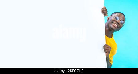 Banner with a black boy coming out from behind a white big board with copy space for text and design Stock Photo