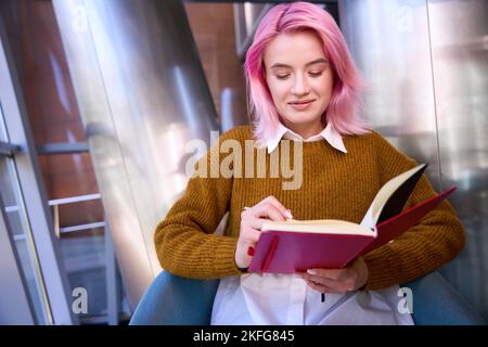 Smiling female making notes in the book Stock Photo