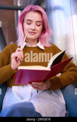Pretty female is making notes to diary Stock Photo