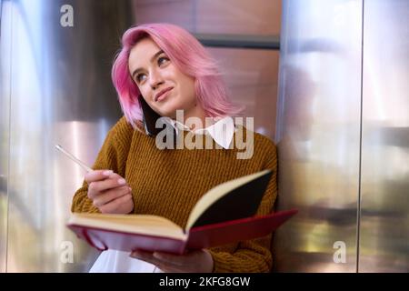 Female making notes and talking on the phone Stock Photo