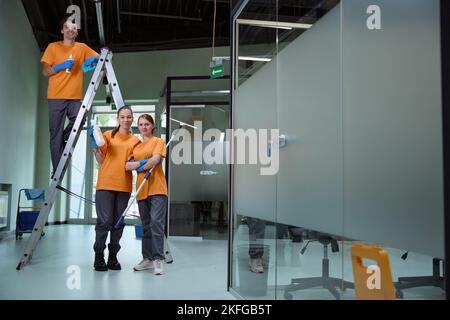 Cleaning company employees posing together after getting the job done Stock Photo