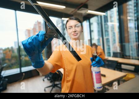Cleaning business worker uses a special glass scraper Stock Photo