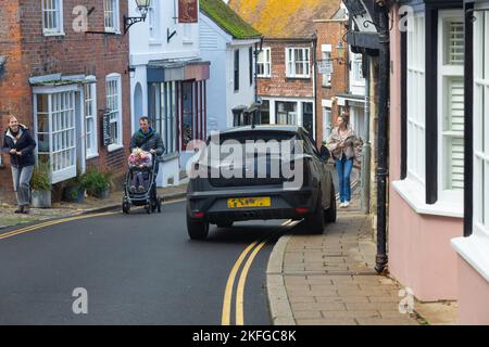 Inconsiderate driver parking on double yellow lines and on the pavement and pushchair pedestrians on road, Rye, East Sussex, uk Stock Photo