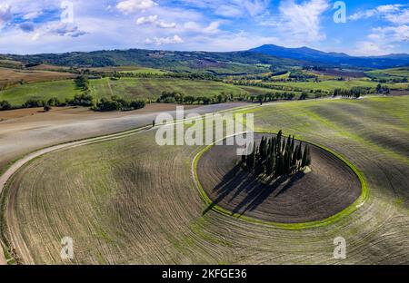 Italy landscape. Amazing Tuscany scenery. Typical countryside with vast fields of Val d'Orcia famous beautiful valley. Aerial drone shot of circle cyp Stock Photo