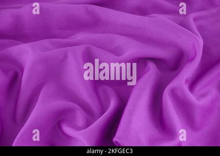 A bright purple wrinkled fabric texture background. Close up. Stock Photo