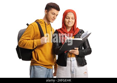 Guy and female student with a hijab reading a book together isolated on hite background Stock Photo