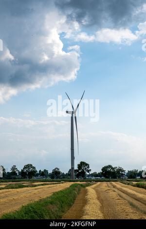 Hamburg, Germany - 07 22 2022: a pinwheel with harvested grain fields against a blue sky with some clouds Stock Photo
