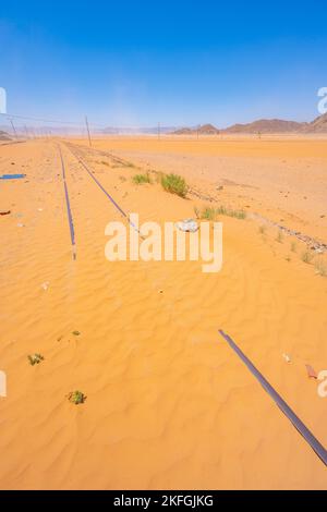 The sand buried train track at Wadi Rum Train Station in Wadi Rum Jordan Stock Photo