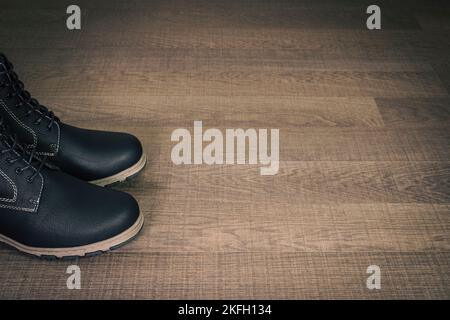 Socks of black boots on wooden surface. Copy space. Stock Photo