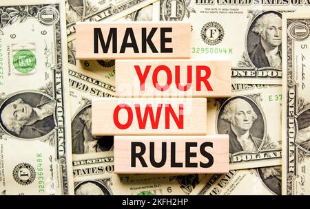 Make your own rules symbol. Concept words Make your own rules on wooden cubes. Beautiful background from dollar bills. Business motivational make your Stock Photo