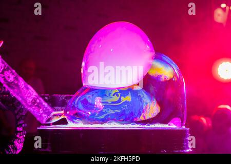 Bubble show for birthday party. Professional presentation with blowing large soap bubbles.Party games.show for children. woman inflates a soap bubble Stock Photo