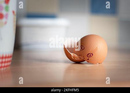 cracked egg shells on the work top with face drawn on the shell Stock Photo