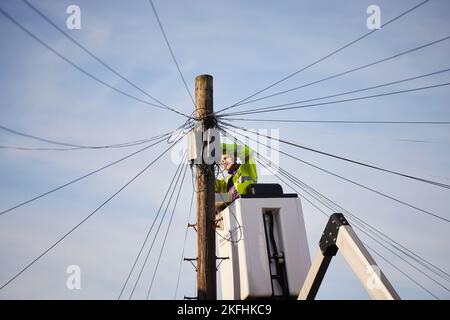 BT openreach engineer working on telephone wires from a cherry picker Stock Photo