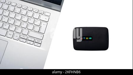 Top view portable pocket internet wifi modem.Close up pocket modem, isolated white background on top of computer. Stock Photo
