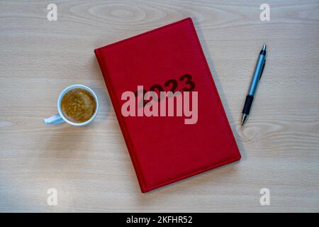 2023 red diary to implement resolutions and new year plan on desk with a pen Stock Photo