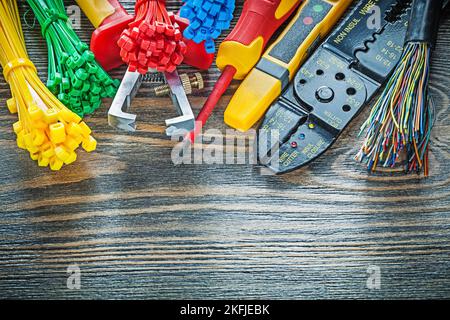Electric tester wires tying cables bolt cutter stripper insulating screwdriver on wooden board. Stock Photo