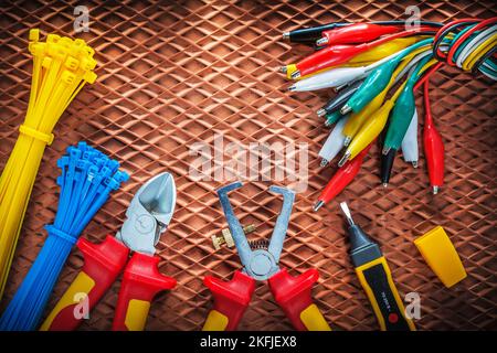 Insulation wire strippers cutter tying cables electric tester crocodile plugs on dielectric mat. Stock Photo