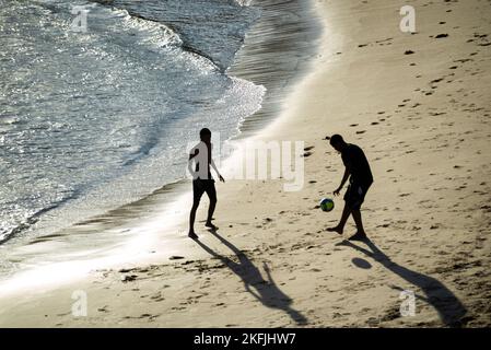 Two young men playing beach soccer at Rio Vermelho beach in Salvador, Bahia in the late afternoon. Stock Photo