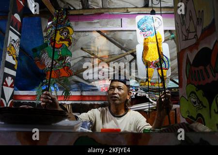 Puppet artist Iskandar Hardjodimuljo shows his 'wayang uwuh' in Yogyakarta. The 'wayang uwuh', made from household waste such as used mineral water bottles, cardboard, food containers, and plastics are sold around $1.59 to $127.38. Stock Photo