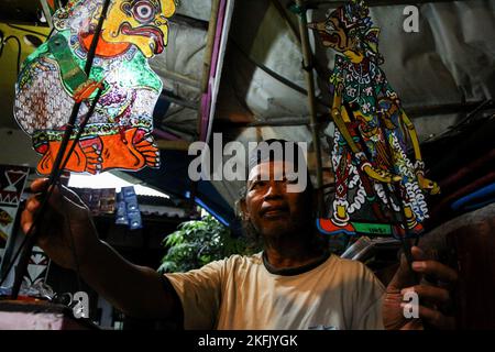 Puppet artist, Iskandar Hardjodimuljo shows his 'wayang uwuh' in Yogyakarta. The 'wayang uwuh', made from household waste such as used mineral water bottles, cardboard, food containers, and plastics are sold around $1.59 to $127.38. Stock Photo